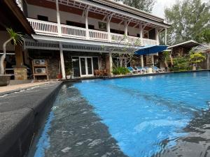 a swimming pool in front of a house at Coral Beach Seaside in Gili Trawangan