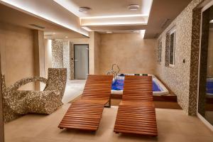 a bathroom with a soaking tub and two wooden stools at LAGUNA Apartament Polanica Residence 14 SPA z tarasem in Polanica-Zdrój