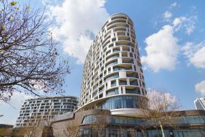 a tall white building with a sky in the background at Ellipse Waterfall 3802 in Midrand