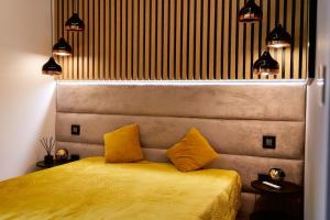 a bedroom with a bed with two yellow pillows at LAGUNA Apartament Polanica Residence 14 SPA z tarasem in Polanica-Zdrój