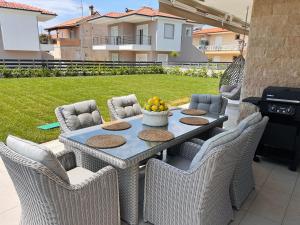 ein Tisch mit Stühlen und Obst auf einer Terrasse in der Unterkunft Royal Apartments - Nikiti in Nikiti
