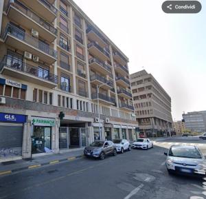 una strada con auto parcheggiate davanti a un edificio di B&B Altrasia a Catania