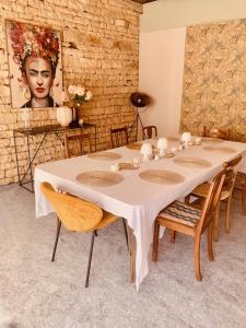 StignyにあるLe domaine aux herbes follesのテーブルと椅子、絵画が備わる部屋