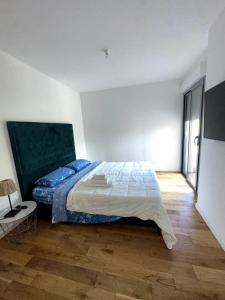 a bedroom with a bed with a blue comforter at Sea View 1B Apartment, Théoule in Théoule-sur-Mer