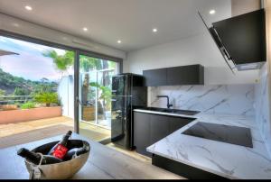 a kitchen with white marble counter tops and a large window at Sea View 1B Apartment, Théoule in Théoule-sur-Mer