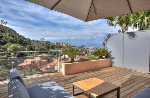 a patio with a table and an umbrella on a balcony at Sea View 1B Apartment, Théoule in Théoule-sur-Mer