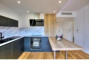 a kitchen with a wooden table and a blue counter top at Sea View 1B Apartment, Théoule in Théoule-sur-Mer