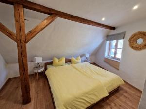 a bedroom with a large bed with yellow sheets at Ferienhaus am hohen Turm in Sulzfeld am Main in Sulzfeld am Main
