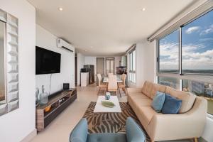 een woonkamer met een bank en een tv bij Palmetto Beach by MOME in Cartagena