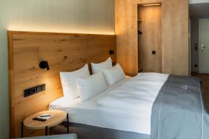 a bedroom with a large white bed and a table at Hotel Nickisch in Schüttorf