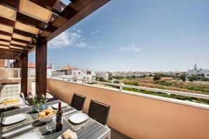 un tavolo e sedie su un balcone con vista di Cabanas Gardens by MY CHOICE a Cabanas de Tavira