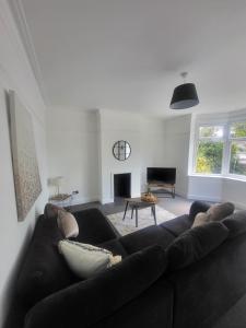 a living room with a black couch and a fireplace at Relaxing Seaside Stay 3-Bed Home Minutes from Hythe Beach in Hythe