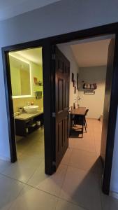 ein Flur mit einem Badezimmer mit Waschbecken und Spiegel in der Unterkunft Habitación en casa de Diana in San Salvador