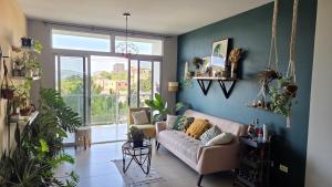 ein Wohnzimmer mit Couch und großem Fenster in der Unterkunft Habitación en casa de Diana in San Salvador