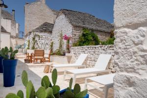 a group of white chairs and tables on a patio at Trulli Lithos Suite in Alberobello