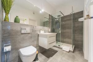 a bathroom with a toilet and a sink and a shower at Deluxe Apartment on Granary Island with Parking - Granaria I & by Noclegi Renters in Gdańsk