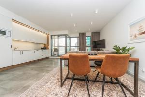 a kitchen and dining room with a wooden table and chairs at Deluxe Apartment on Granary Island with Parking - Granaria I & by Noclegi Renters in Gdańsk