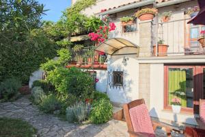 un edificio con sillas y flores en un jardín en Apartments Nevija, en Rovinj