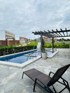 a swimming pool with two chairs and a pergola at Nosso Chalé in Serra de São Bento