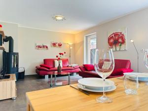 un salon avec des canapés rouges et une table dans l'établissement Hus bei de Dün, à Böhl