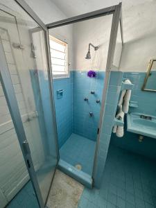 a blue bathroom with a shower and a sink at Sunset Mompracem in Chicxulub, Yucatan in Chicxulub