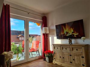 a living room with a sliding glass door with a fire on the wall at Ferienwohnungen Burgfried in Wernigerode