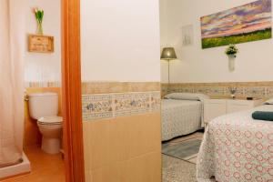 mała łazienka z toaletą i łóżkiem w obiekcie Aire Hostal en Los Alcores w mieście El Viso del Alcor