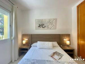 a bedroom with a bed with two tables and a window at VH Costa Blanca - APARTAMENTO ABANTOS in Casas de Torrat +39 photos