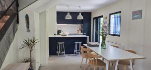 a kitchen and dining room with a table and chairs at Cottage Playa Cabeiro in Porto do Son