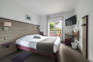 a bedroom with a large bed and a window at Contact Hôtel O'Nice Saintes in Saintes +88 photos