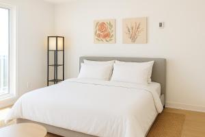 una camera da letto bianca con un grande letto con lenzuola bianche di Luxury Stay for NYC visit Jersey City 7 Min Walk NYC Train Station a Jersey City