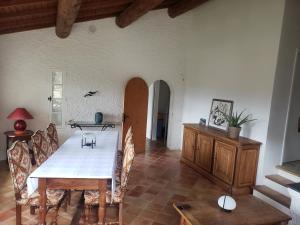 a dining room with a white table and chairs at Les Claux des Oliviers in Moustiers-Sainte-Marie
