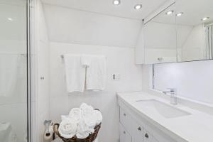a white bathroom with a sink and a mirror at Studio 7744 Ranch Austin Venue and Rentals in Austin
