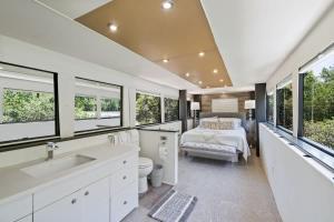 a bedroom with a bed and a bathroom with windows at Studio 7744 Ranch Austin Venue and Rentals in Austin +21 photos