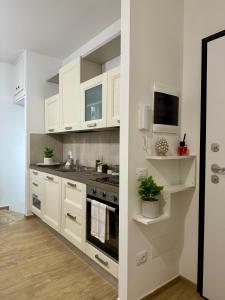 a kitchen with white cabinets and a stove at Dimora del Teatro in Spoleto