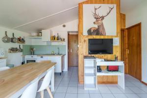 una cocina con mesa y TV. en Chalet des cimes - Avec jardin, en La Bresse 6 fotos más