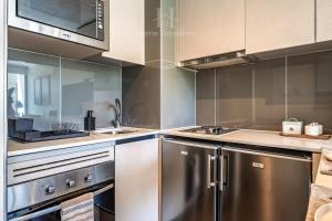 cocina con electrodomésticos de acero inoxidable y microondas en HT Acogedor Dpto en Santiago con Wifi 3PAX, en Santiago