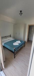 a bedroom with a bed with a blue comforter at Vasiliki Apts in Vasiliki +8 photos