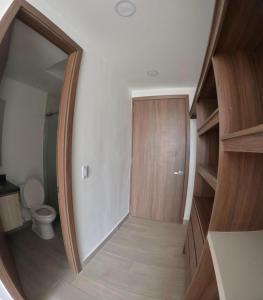 a bathroom with a toilet and a hallway with a mirror at Hermoso apartamento serena del mar #1 in Puerto Tierrabaja