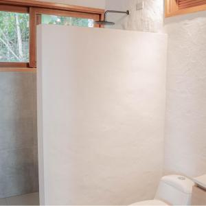 a white bathroom with a toilet and a window at Kasaurora in Tobia
