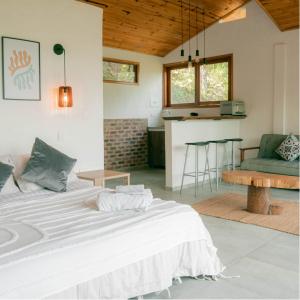 a bedroom with a large white bed and a kitchen at Kasaurora in Tobia