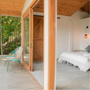 a bedroom with a bed and a chair on a porch at Kasaurora in Tobia