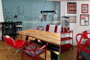 a dining room with a wooden table and red chairs at Hütte31 in Goslar