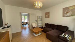 a living room with a brown couch and a table at Dom wakacyjny z basenem i sauną GWIZD Ustronie Morskie in Grąbnica