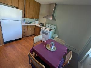 a kitchen with a table and a white refrigerator at Mariner motor hotel in Collingwood +30 photos