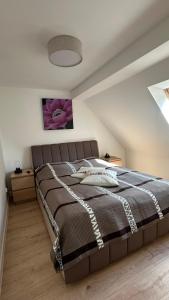 a bedroom with a large bed in a attic at Dom wakacyjny z basenem i sauną GWIZD Ustronie Morskie in Grąbnica