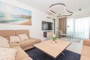 a living room with a couch and a table at Seafront Villa Serena with pool and seaview in Privlaka