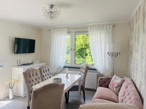 a living room with a pink couch and a table at Maison Lily Apartment 1 in Bad Lauterberg