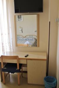 a desk with a mirror and a bed in a room at Hotel Hamburg in Senigallia