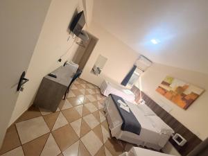 a hospital room with two beds and a television at Itaipu Hotel in Foz do Iguaçu